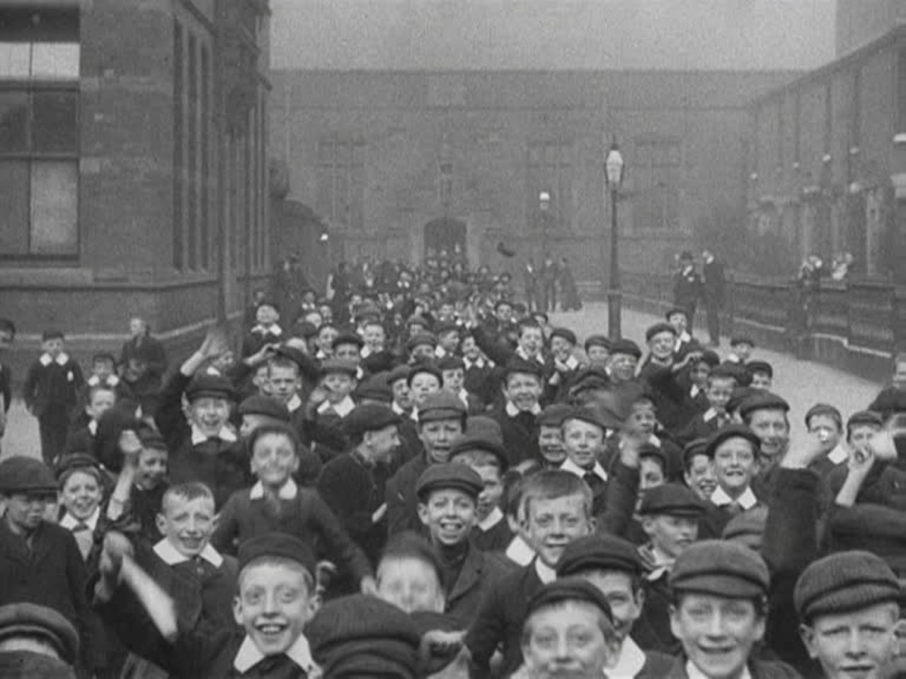 Jubilant schoolchildren spill out of a Catholic primary school in Edwardian Preston.