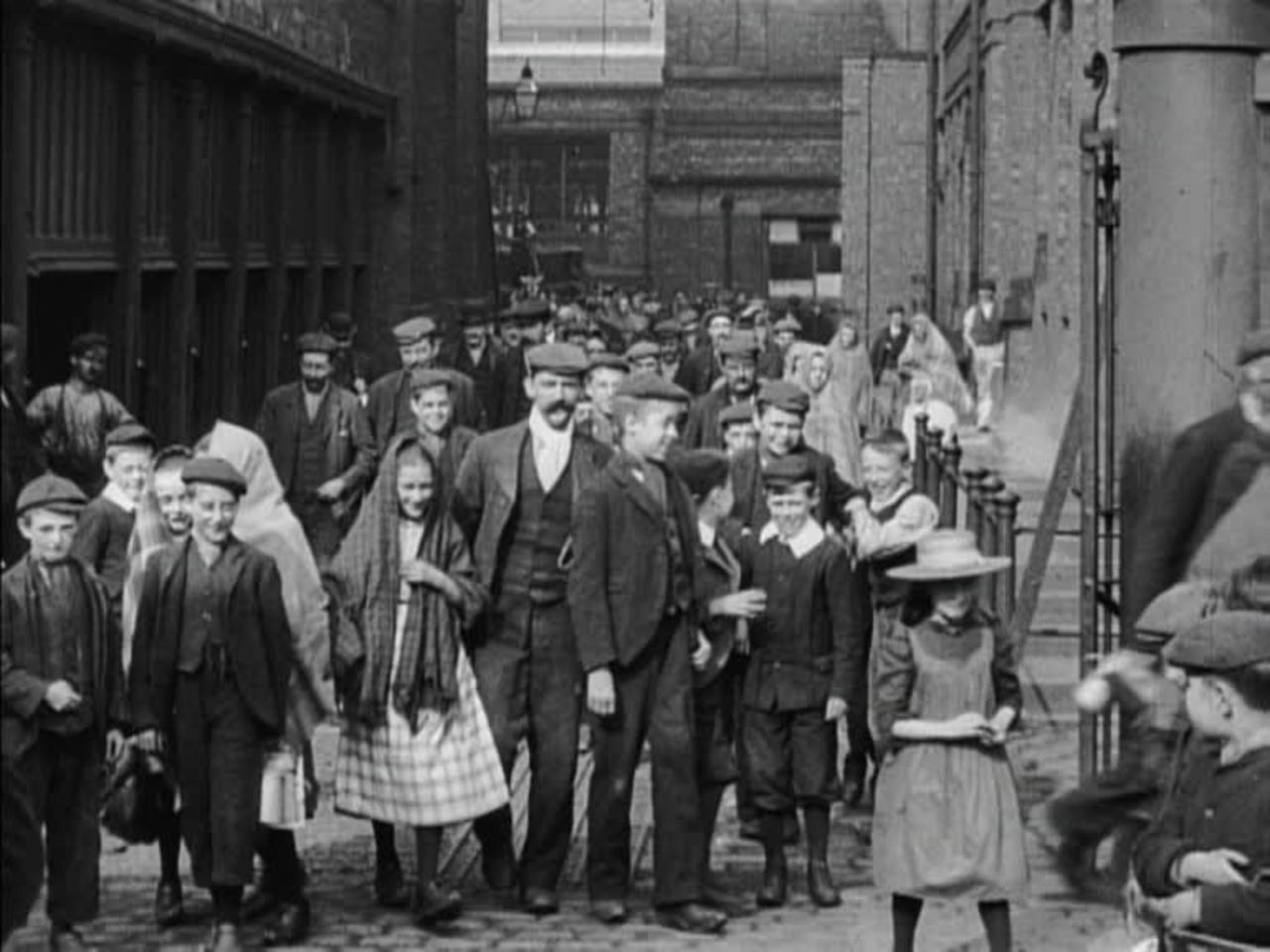 An assortment of Edwardian workers, including many mischievous children who are far from camera-shy.