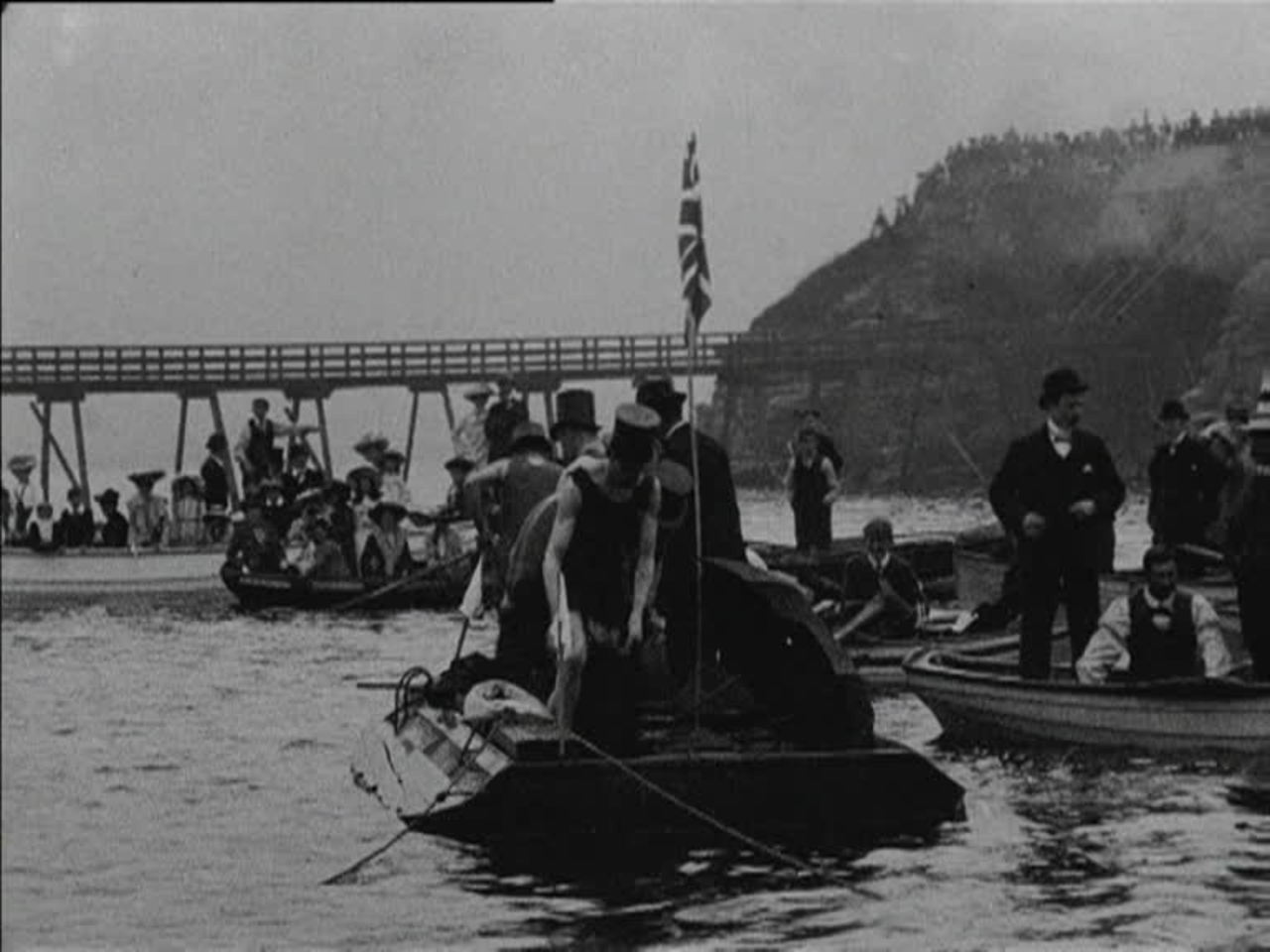 Edwardian crowds enjoy a fancy-dress swimming race.