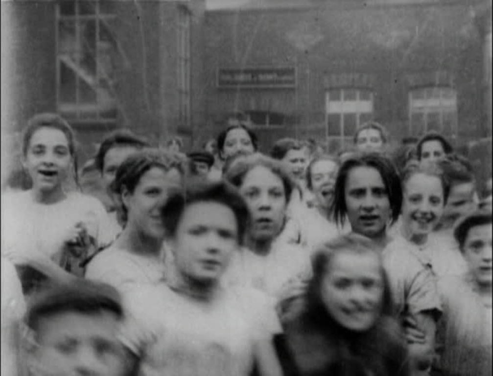 The largely female workforce of an Edwardian Lancashire factory parades past the camera.