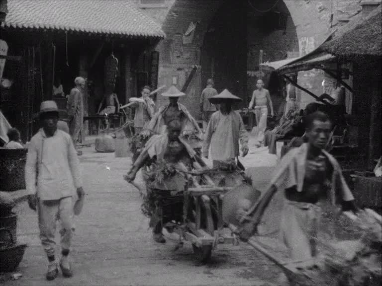 Could the hidden hand of a newsreel company be directing this procession of weary Chinese labourers?